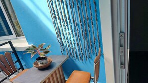 A small outdoor seating area with a table, chairs, and a potted plant. - Studio nono (Pointe-à-Pitre)