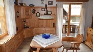 Ein Esszimmer aus Holz mit Tisch, Stühlen und einer Hängelampe.