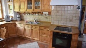 Eine Küche mit Holzschränken, einer gefliesten Spritzschutzleiste und einem Geschirrspüler.