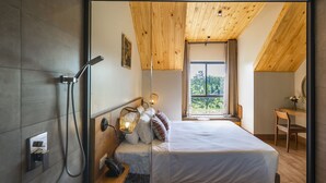 A modern bedroom with a large bed, a wooden ceiling, and a view of the outdoors. - Hami Garden (Tan An)