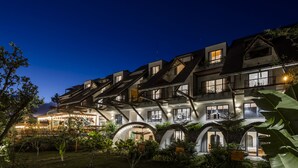 A multi-story building with a modern architectural design, featuring balconies and large windows. - Hami Garden (Tan An)