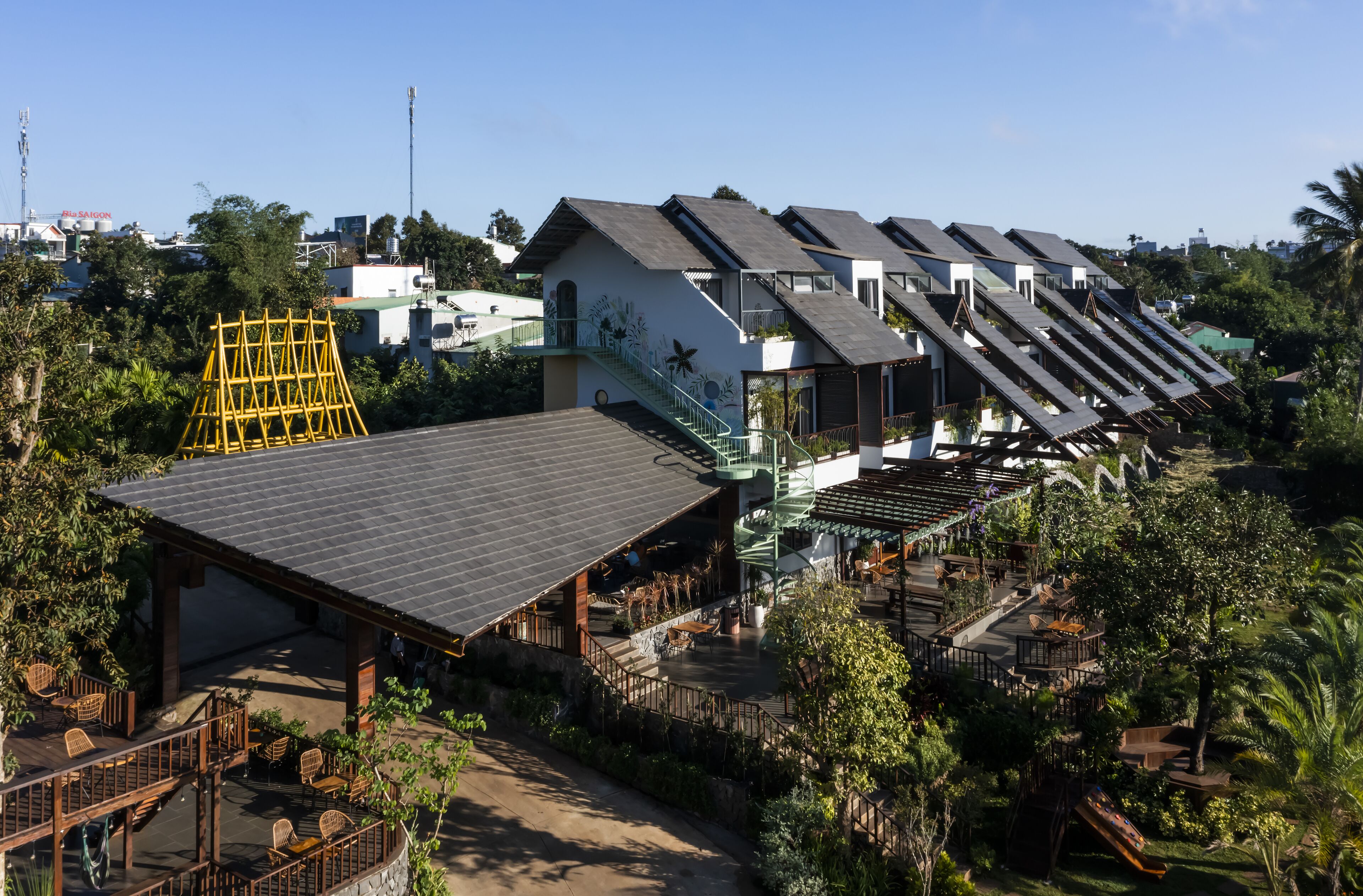 Un resort con varias construcciones, un patio cubierto y un área de juegos.