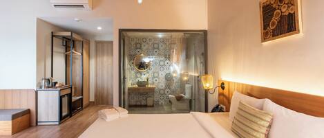 A hotel room with a bed, bedside table, and a bathroom visible through an open door.