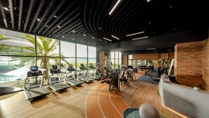 Ein modernes Fitnessstudio mit Laufbändern, Trainingsgeräten und einem großen Fenster mit Blick auf eine schöne Landschaft.