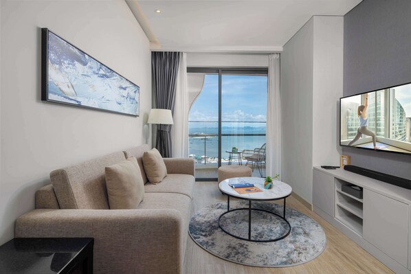 A modern living room with a sofa, coffee table, and a flat-screen TV.