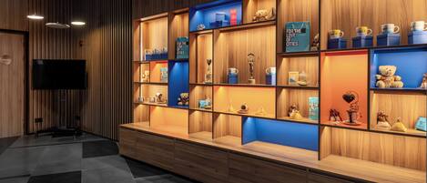 A hotel lobby with wooden paneling, a flat-screen TV, and shelves displaying trophies and souvenirs.