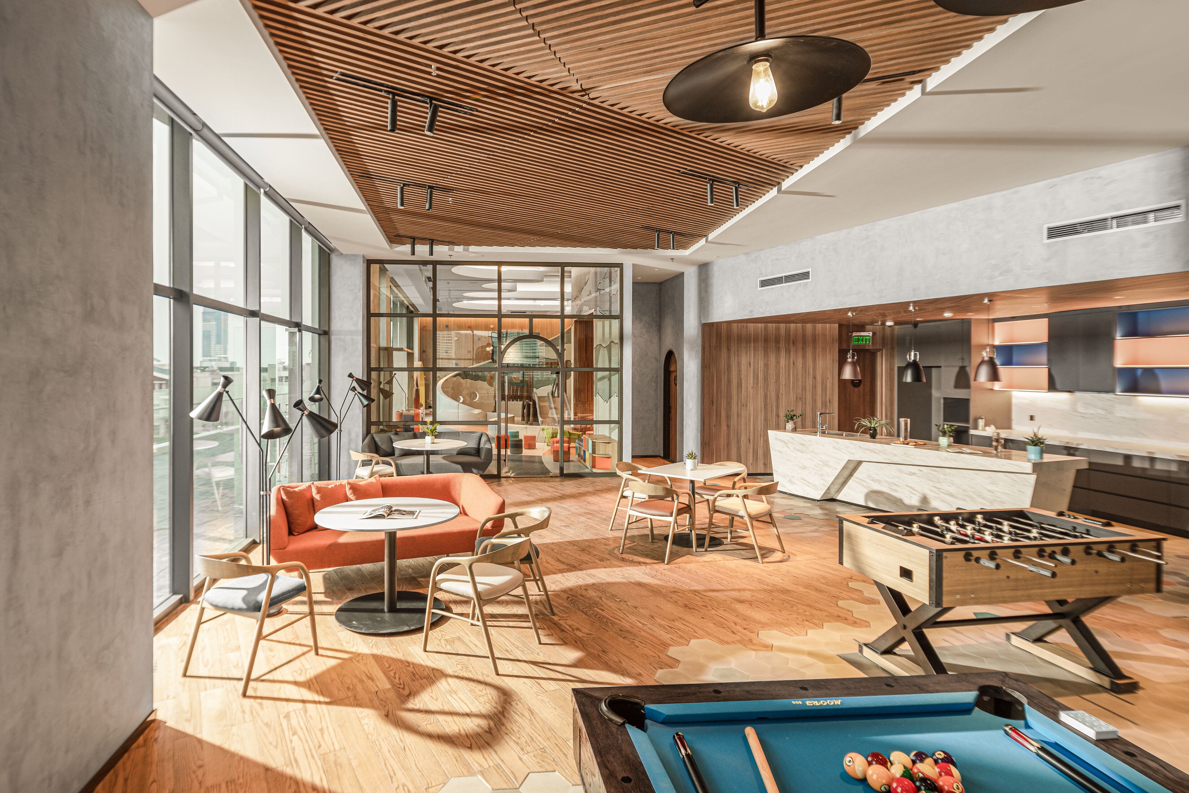 A modern lounge area with a pool table, foosball table, and comfortable seating.