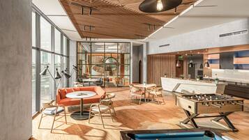 A modern lounge area with a pool table, foosball table, and comfortable seating.