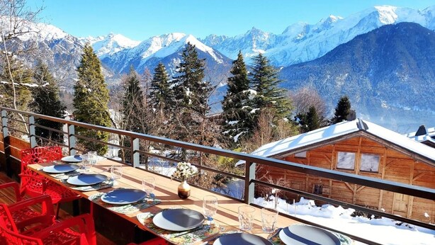 A dining area with tables set for four, overlooking a snowy mountain landscape. - New Spacious Appart. Incredible view of Mt Blanc (Passy)