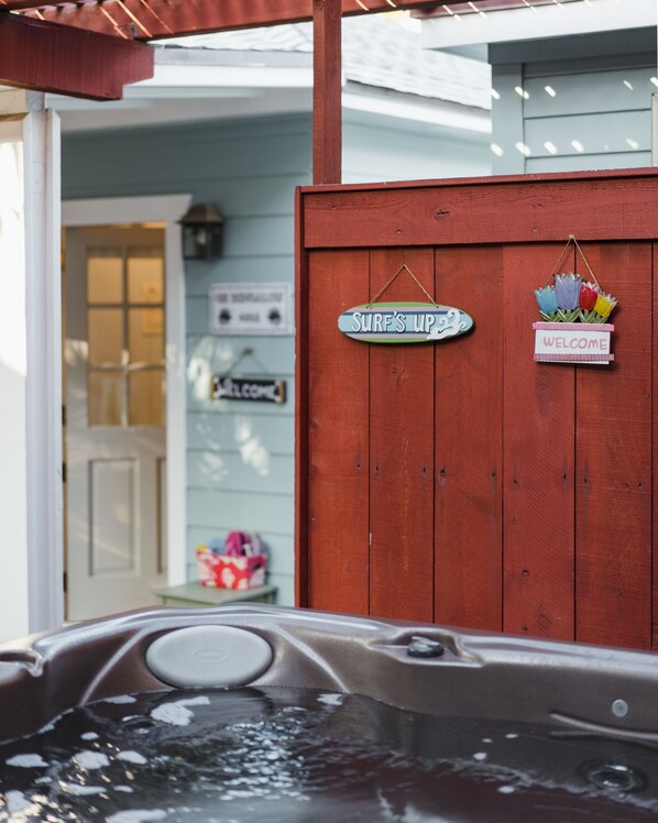 A wooden fence with signs reading "SURF'S UP" and "WELCOME". - OB Bungalow (San Diego)