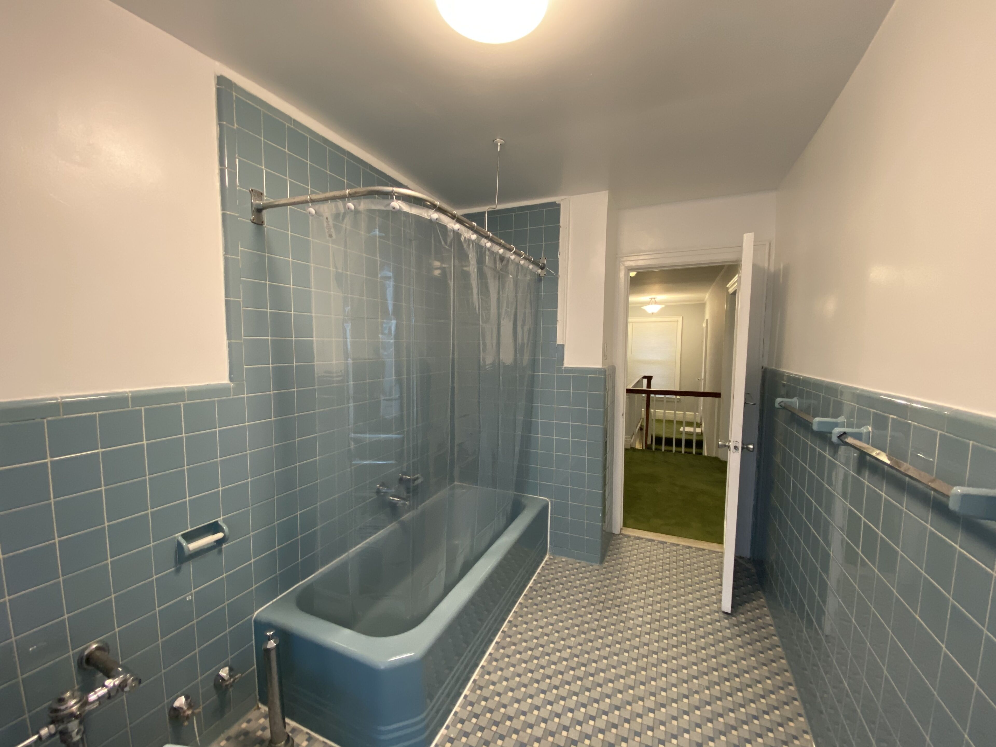 A bathroom with a bathtub, shower, and a tiled floor.
