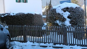 A snow-covered parking area with a wooden fence and a sign indicating parking restrictions. - Relaxation in the Ammergau mountains, centrally located (Oberammergau)