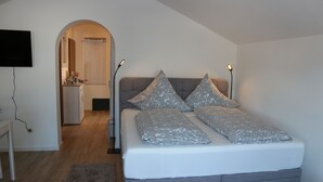 A bedroom with a bed, a desk, and a TV. - Relaxation in the Ammergau mountains, centrally located (Oberammergau)