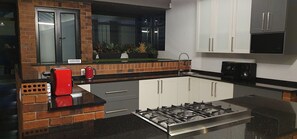 Kitchen features a central island with a gas stove, brick accent wall, and a window above the sink.