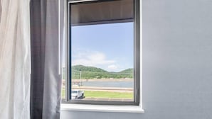 A window with a view of a river and hills. - Quality Inn (New Martinsville)