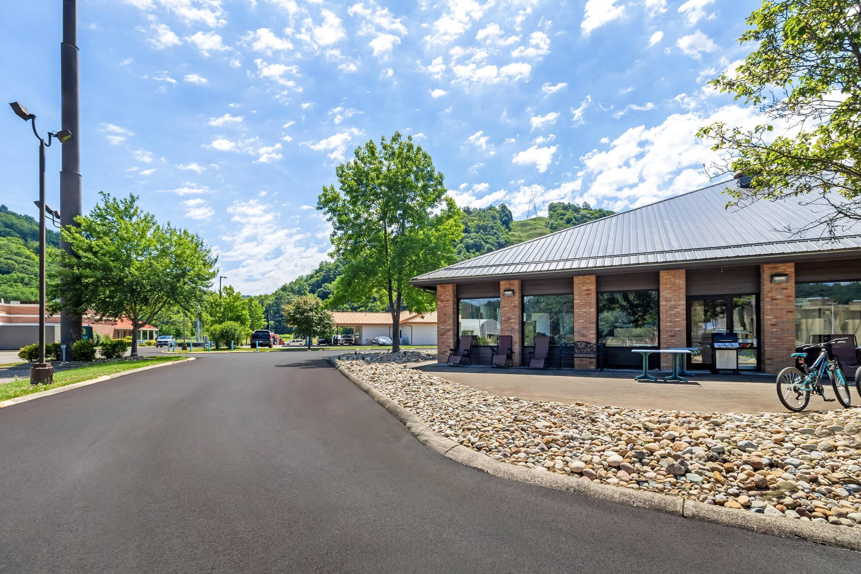 A building with a covered patio area, a paved road, and a bicycle parked outside.