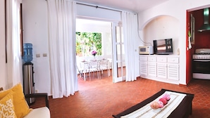 A room with a dining area, a kitchen with a stove and microwave, and a water dispenser. - Amazing Villa Bavaro Beach (Punta Cana)