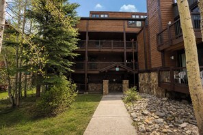 A multi-story building with a stone facade and wooden balconies. - Sundowner Mountain View Condo • Walk to Slopes & Main St  • Pool Access (Breckenridge)