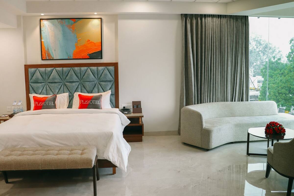 Ein Hotelzimmer mit Bett, Sofa, Couchtisch und einem Bild an der Wand.