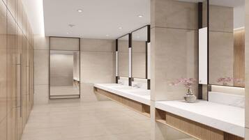 Un bagno moderno con un ampio lavabo, diversi lavandini e uno specchio grande.