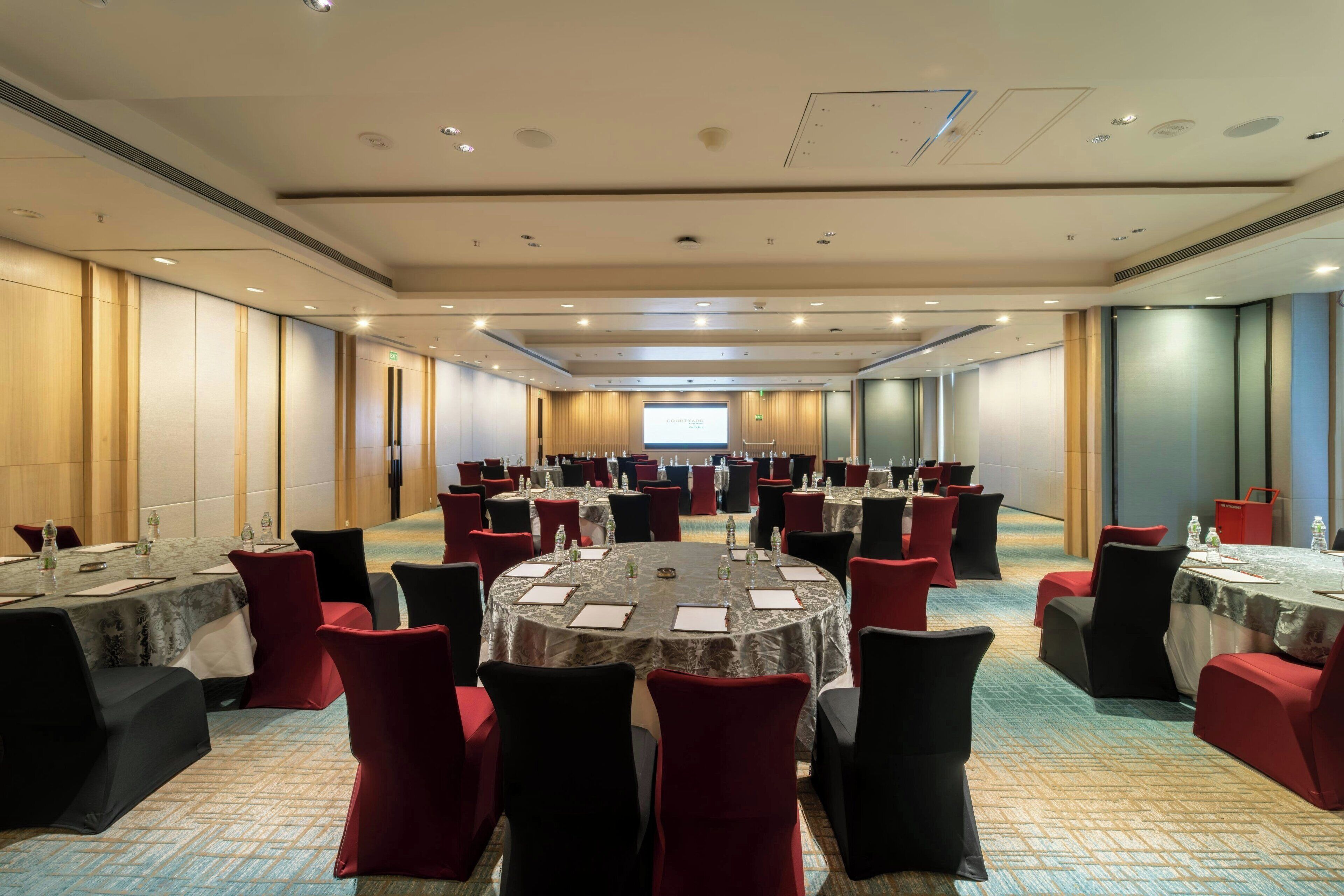 A conference room with multiple tables and chairs, equipped with water bottles and nameplates.