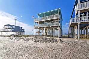 Un immeuble situé en bord de mer, doté de nombreux balcons et d’une promenade couverte.