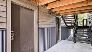 A garage door, a staircase, and a concrete pathway leading to a building. - Cozy Big Sky Studio ~ 1 Mile to Mtn Village! (Big Sky)