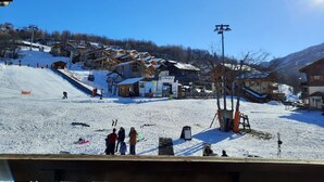 A ski resort with wooden buildings, a ski lift, and a clear blue sky. - Apartment at the foot of the slopes - 4 guests (Les Belleville)