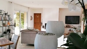 Ein Wohnzimmer mit Sofa, Couchtisch, Fernseher und Bücherregal.