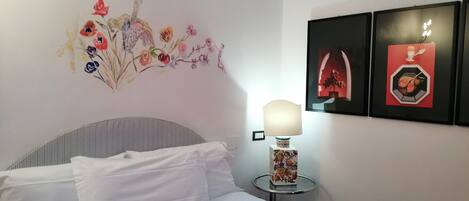 Una habitación de hotel con cama, lámpara y decoración en la pared.