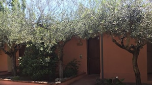 A courtyard with a building, trees, and a paved walkway. - Gaia B&b (Castrovillari)