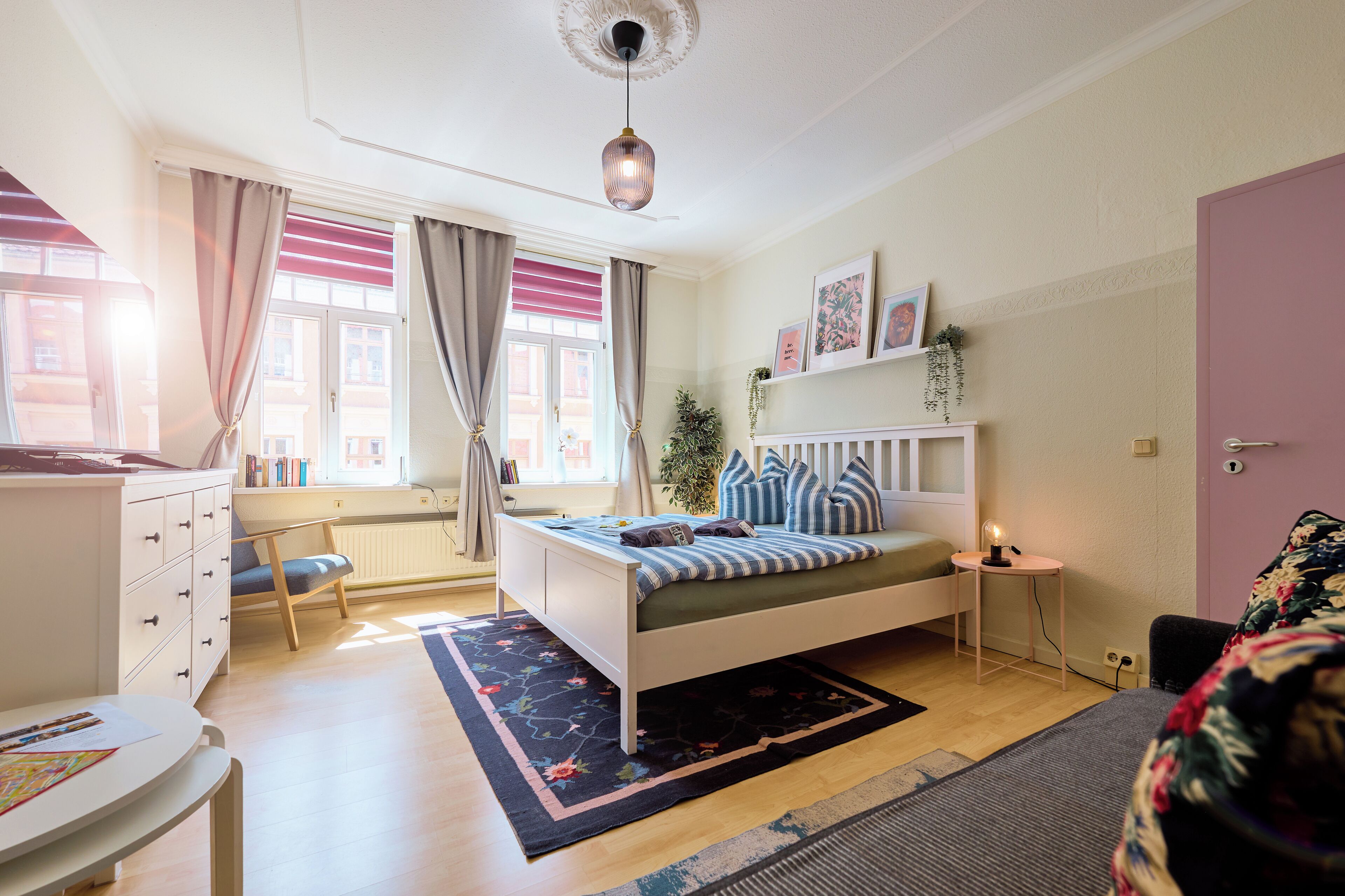 A bedroom with a bed, bedside table, and a window with curtains.