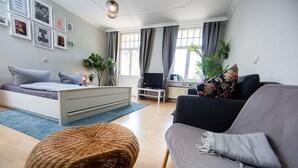 A modern living room with a bed, sofa, and a TV.