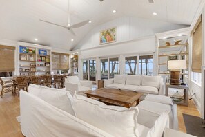 Relax in this stylish living area with a high ceiling, large window, and comfortable seating.