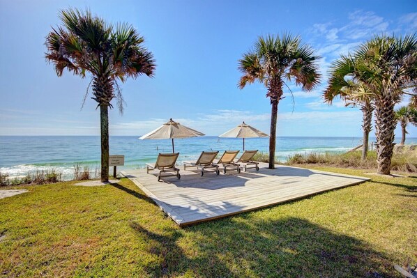 Relax on the deck with comfortable lounge chairs and umbrellas, surrounded by lush greenery and the soothing ocean views.