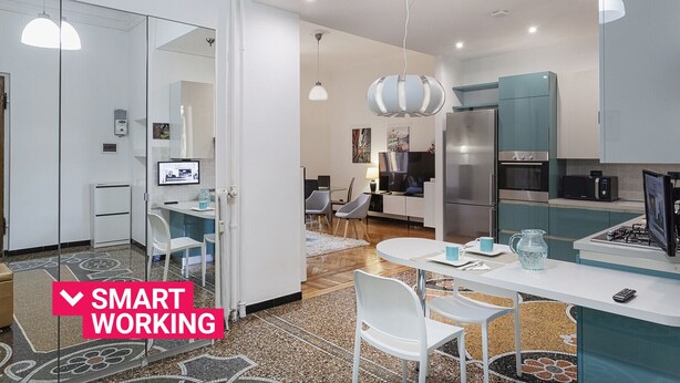 Eine moderne Küche mit Essbereich, inklusive einer Arbeitsstation mit Computer und Fernseher.