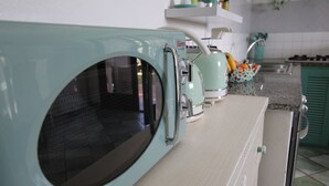 Une cuisine équipée d’une cuisinière de style vintage et d’un four à micro-ondes.