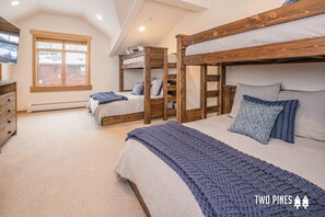 A bedroom with bunk beds, a large window, and a wooden dresser. - Inviting Spanish Peaks Townhome|Private Hot Tub| 15 min Drive to Resort (Big Sky)