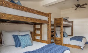 Una habitación con literas, ventilador de techo y ventana.