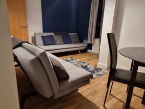 Appartement, 2 grands lits | Salle de séjour | Télévision de 30 pouces avec chaînes numériques