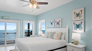 A bedroom with a bed, nightstand, and artwork on the wall. - Big Blue Heaven: Gorgeous Gulf Views, Swim Spa, 7 Bedrooms! (Cape San Blas)
