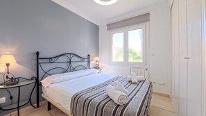 A bedroom with a bed, two bedside lamps, a window, and a radiator. - Solea Mare by Midelisa (oliva nova golf)