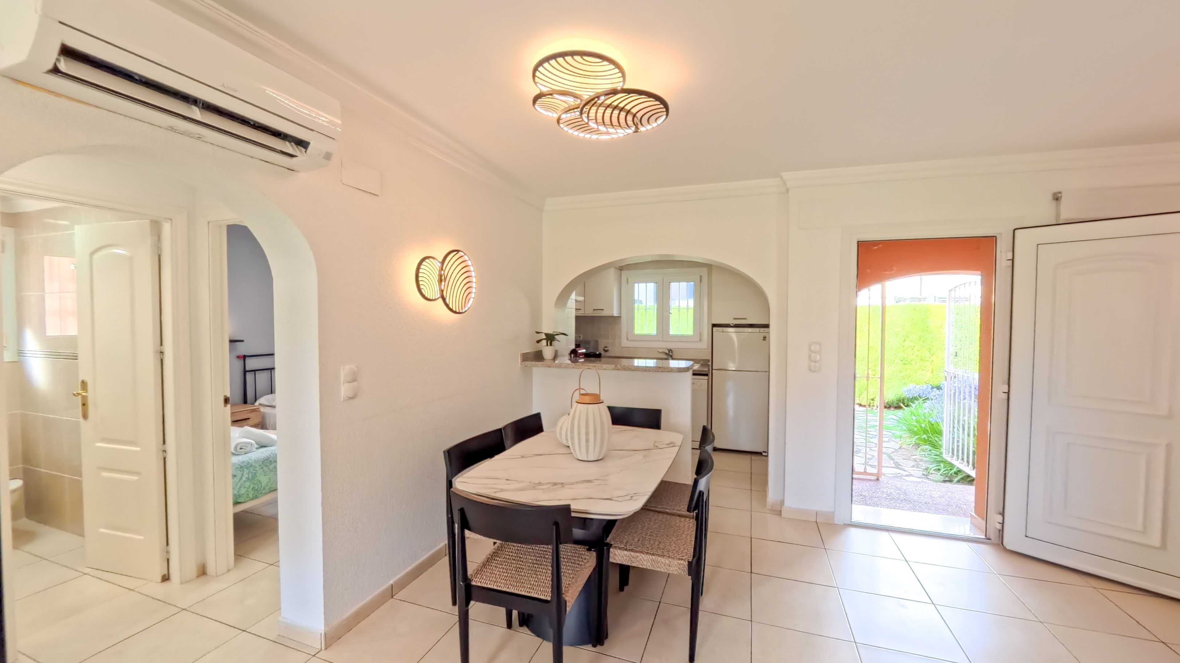 A modern kitchen with a built-in oven, a refrigerator, and a window.