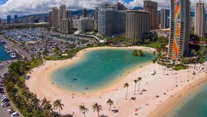 A coastal cityscape with a large sandy beach, a marina, and high-rise buildings. - The Watermark (WM1102) Luxury 11th-floor 2 BDR, balcony, AC, remote work (Honolulu)