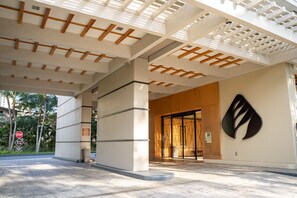 Une entrée moderne avec un plafond au design géométrique, un logo bien visible sur le mur et un panneau de signalisation en premier plan.
