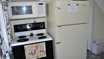 Une cuisine compacte équipée d’une cuisinière, d’un four à micro-ondes et d’un réfrigérateur.