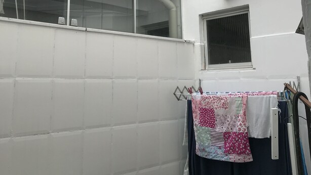 A small, enclosed space with a skylight, a window, and a metal table with a green tablecloth. - Near Praia do Forte - second block (Cabo Frio)
