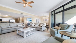 A spacious living room with a large sofa, a coffee table, and a dining area. - New to the Rental Market!  Lazy River and Water Slide! (Orange Beach)
