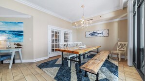 A dining area with a wooden table, benches, and a chandelier. - New to the Rental Market!  Lazy River and Water Slide! (Orange Beach)