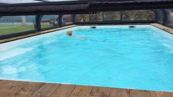 Een buitenzwembad en een verwarmd zwembad